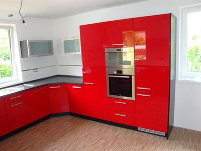 Červená kuchyňská linka s kamennou pracovní deskou